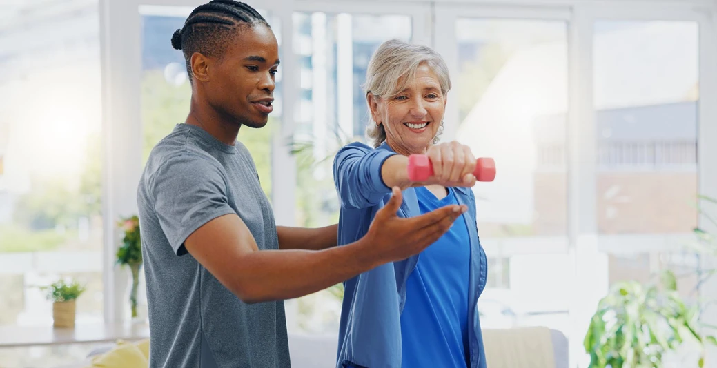 Two people's hands holding and stretching red resistance band during exercise