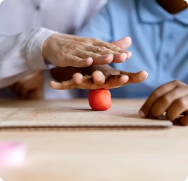 female physical therapist assists older man with green dumbbell exercise