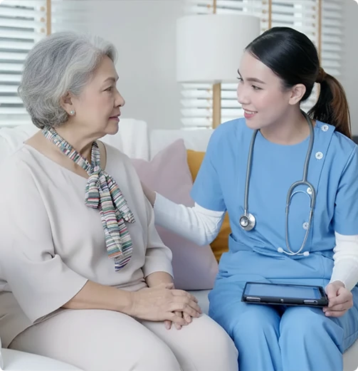 Caregiver providing emotional support to senior woman during in-home healthcare consultation