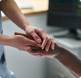Caregiver holding elderly patient’s hand as a gesture of comfort and support, close-up detail