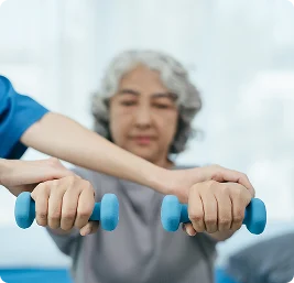 Senior woman performing light dumbbell exercise during physical therapy session, close-up of hands and weights