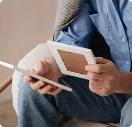 Person holding and looking at printed photographs.