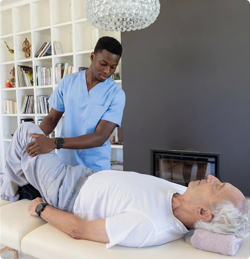 Physical therapist performing a leg stretch on a senior man lying on a treatment table
